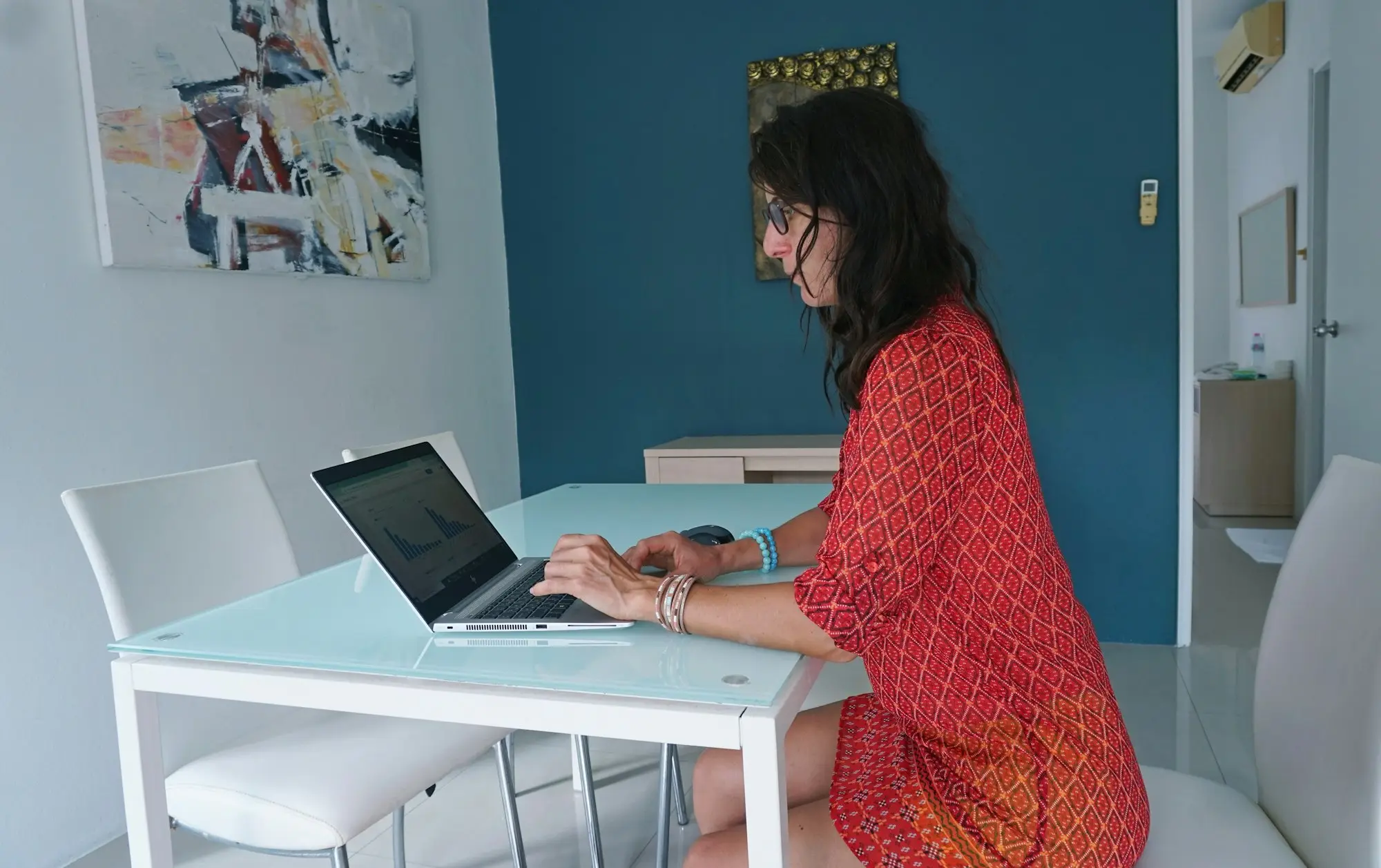 Business owner working on a laptop at a bright desk, filling in an online enquiry